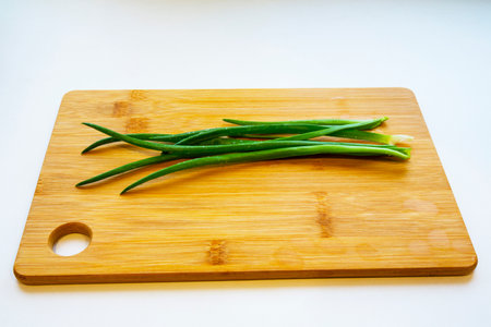 Fresh green onions on a cutting board. Drops of water on a fresh cut green onion.の写真素材