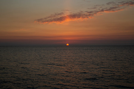 Beautiful sunset above the sea The setting sun over the ocean, in the evening, the sun sinks into the waterの写真素材