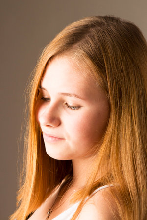 Arrogant facial expression, girl looking down, condescending grin, emotions of the seriesの写真素材
