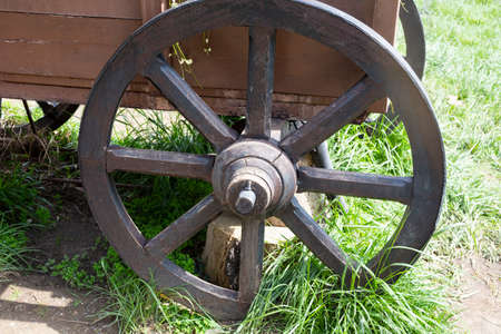 old vintage wooden wheel. wooden cart wheel of the 19th century. vintage metal parts made in a blacksmith shopの写真素材