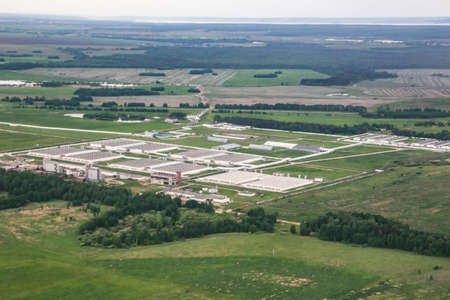 bird's-eye view of industrial buildings among green fieldsの写真素材