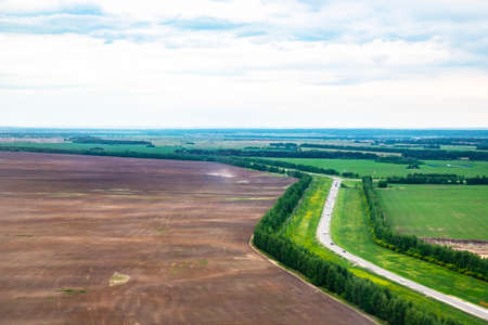Aerial View Of Highway Road Through Spring Forest Landscape. Top View Of Truck Tractor Unit Prime Mover Traction Unit In Motion On Freeway. Business Transportation, Trucking Industry. Concept - the way homeの写真素材