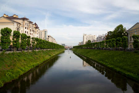 The river flows through a canal in the city. Panorama of the residential central districts of the city of Kazan across the river, Russia.の写真素材