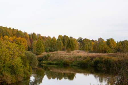 A beautiful autumn day on the river bank. Autumn background.の写真素材
