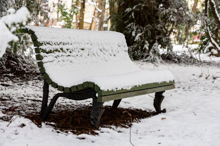 A pack bench under snow as the snow continues to fall for a wintery sceneの写真素材