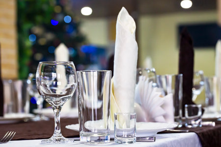 Served dinner table in a restaurant. Restaurant interior, lights from a Christmas tree in the...