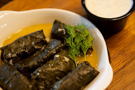 A plate of delicious stuffed grape leaves with parsley garnish.の写真素材