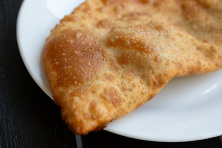 fried pies with meat on white plate - chebureks oriental cuisine