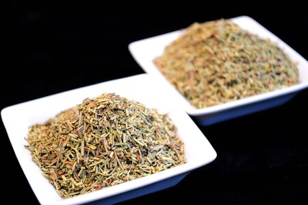 Herbs and spices in white bowls isolated on blackの写真素材