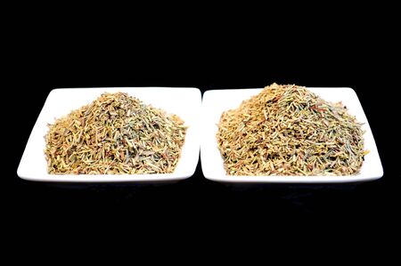 Herbs and spices in white bowls isolated on blackの写真素材