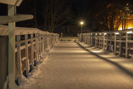 The lamppost shines on a dark bridgeの写真素材
