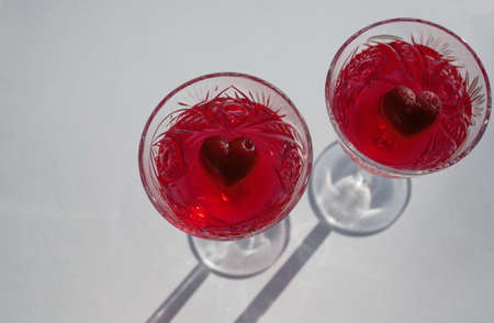 Love concept. Heart symbol inside crystal glasses with red alcoholic drink for two. Holiday, Valentine's Day, an event for a couple in love. view from aboveの写真素材