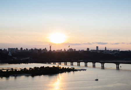 Kyiv from a bird's eye view with a bridge over the Dnieper River and a view of the Pechersky district at sunset. urban landscape on the capital of Ukraine. stop the warの写真素材