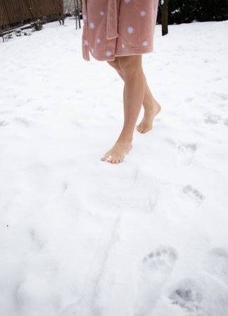 Bare female legs walking barefoot on freshly fallen snow. Healthy lifestyle concept. Improve your health, increase immunity in the winter season. love winterの写真素材