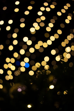 defocused christmas garlands of glowing yellow light bulbs. Abstract festive background, bokeh