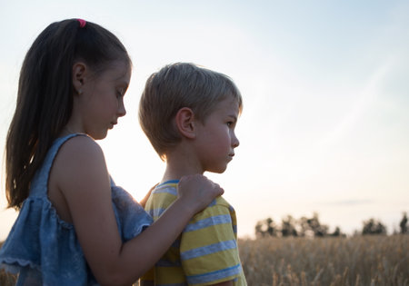 sensual emotional portrait of two sad children in profile, a boy and a girl aged 6-7. support each other, care of the sister about the younger brother. Fear, sadness, resentmentの写真素材