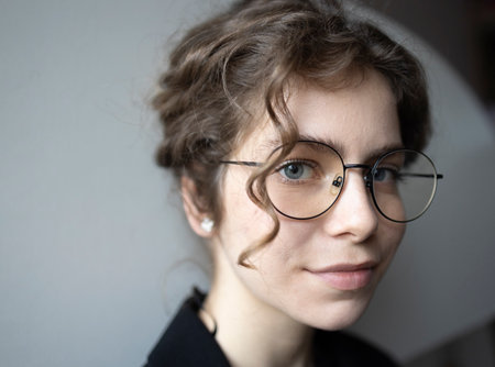 face portrait confident teenage girl 18 years old, schoolgirl, college student looking at camera. young smart woman with glasses. selective focus, copy spaceの写真素材