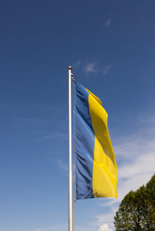 large Ukrainian yellow and blue flag flutters against tskyの写真素材