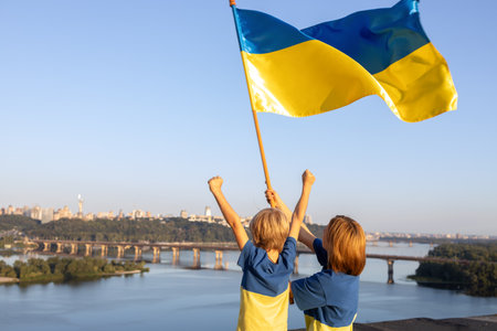 Mom and son stand high on roof of house against sky and Dnieper River in Kyiv. Patriotism, drawing attention to war in Ukraine. Support Ukraine. Independence Day. faith in victory. stop the warの写真素材