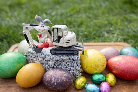 model of a toy excavator on a piece of granite, a souvenir rabbit, colorful eggsの写真素材