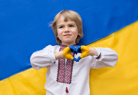 children's hands painted in the colors of the Ukrainian flag are folded in the shape of a heart. patriotism children against war. Support Ukraine. Gratitude for global support for Ukraineの写真素材