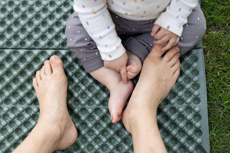 Bare feet of a small and large child next to each other. The concept of unity, different generations in the familyの写真素材