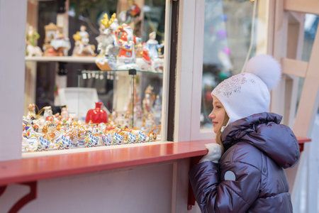 The girl looks at the window and chooses souvenirs. Christmas Fair.の写真素材