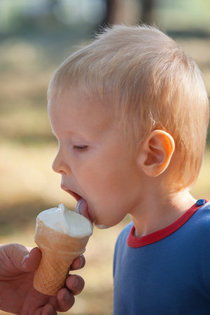 boy with pleasure eating ice cream close-upの写真素材