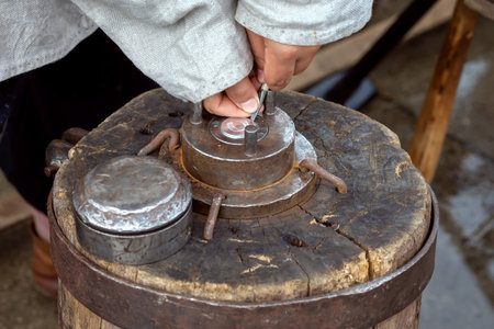 Blacksmith works hammer minting ancient coin during historical reconstruction amateur festiva. Tool for creating coins by embossing.の写真素材