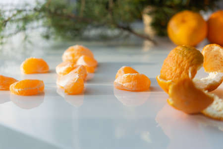 Christmas composition of tangerines and Christmas trees. Bright holiday card. Top view of tangerines and Christmas tree branches. New year's design. Beautiful shadows from the sun on a white table.の写真素材