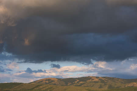 Gray storm clouds over the mountain. Autumn landscape before the rain. Dark blue terrible storm...