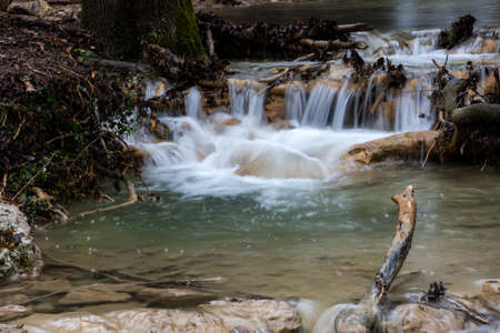Mountain river in the autumn forest. Streams of water on a long exposure. Raindrops on the river....