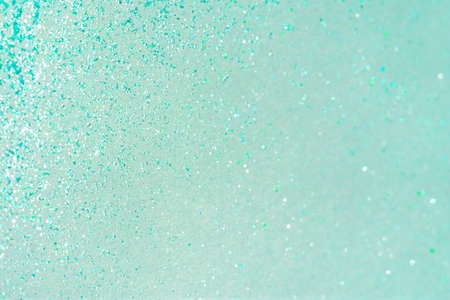 Abstract mint background with small sequins. The trending color of 2021. Bright greenish-turquoise shades. Christmas holiday shimmering background. Layout of a postcard or banner for the New year.の写真素材