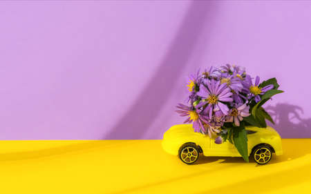 Composition of autumn flowers on the car. The concept of delivery of flower bouquets. Purple...