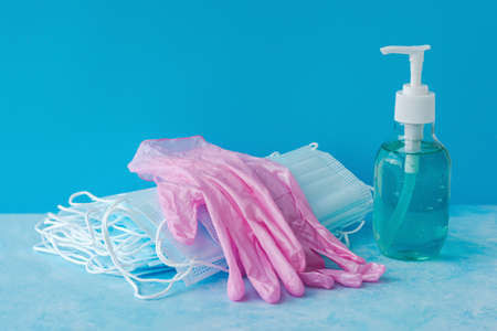 Medical masks, antiseptic and pink gloves on blueの写真素材
