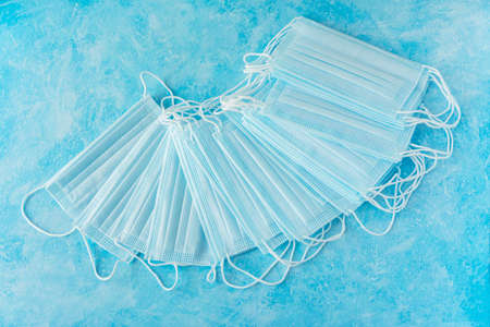Medical masks on a cold blue-white background fan. Prevention of coronavirus and flu. A large number...