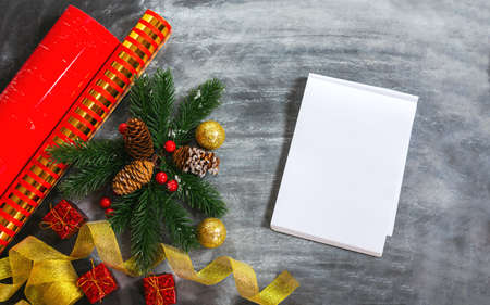 Christmas decorations, wrapping paper, and an empty notebook. Top view of a composition of spruce...