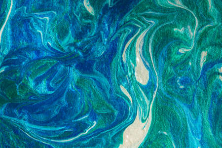 Turquoise blue abstract background in the technique of fluid art. liquid art pattern. Original art. Simulation of the depth of the ocean and the sea surface. Modern design. Drawing with acrylic paintsの写真素材