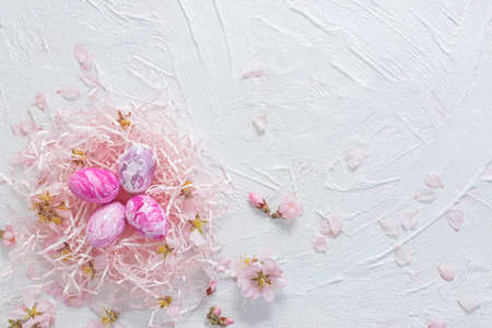 Easter composition of painted eggs and almond flowers on a pink wooden background. Happy Easter...