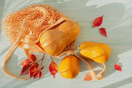 Orange pumpkin autumn red leaves on a wooden table. Creative holiday composition for Thanksgiving....