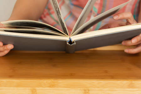 A book in the hands of a young woman close-up. A girl is reading a book, a student is studying, a...