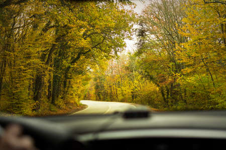 Autumn landscape road. Colorful autumn nature from the car window. Blurry fast traffic on an asphalt...