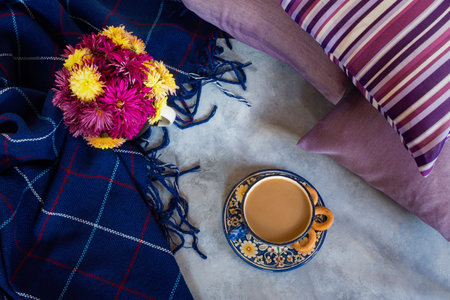 Autumn composition. Coffee chrysanthemums in a cage with a top view flat layout. The concept of comfort, autumn-winter cold. Layout for the design. Cozy still life with a blue blanket, pillows, bagelsの写真素材