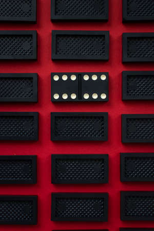 Domino minimalistic red and black background. Conceptual modern art design. Six by six is an open card. Gambling, mysterious flat background top view. Rectangular rows of dominoes. Abstract minimalismの写真素材