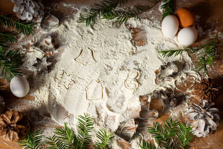 Christmas metal molds for ginger cookies on a wooden table with flour. The concept of festive curly...