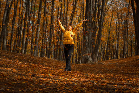 A beautiful young business woman is sitting at her desk. Upset looking at the phone is a natural working moment for a business woman in a jacket. An open laptop, a diary, stationery. Workflow, sadnessの写真素材