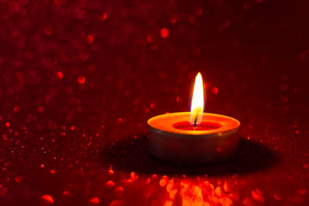 Candles red glitter background. Blurry red background with a little bokeh. Beautiful festive sensual composition. The concept of Valentine's day, wedding, birthday. Merry Christmas and Happy New Yearの写真素材