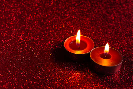 Candles red glitter background. Blurry red background with a little bokeh. Beautiful festive sensual composition. The concept of Valentine's day, wedding, birthday. Merry Christmas and Happy New Yearの写真素材
