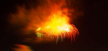 Fireworks banner. Scarlet illuminated background. Multicolored holiday lights panorama copy space....
