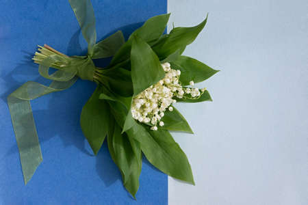 flower composition. Bouquet of lilies of the valley. Spring white flowers on a gray green...